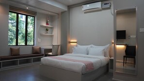 Suite Deluxe, aria condizionata | Minibar, una scrivania, tende oscuranti, ferro/asse da stiro