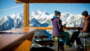 Two people sitting at a wooden table with a mountain view. - The Keep | Ski-In/Out Toby Chair | Ground Floor (Panorama)