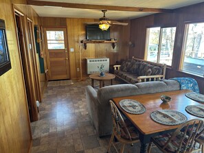 Un interior de madera con sofá, mesa de comedor y sillas.