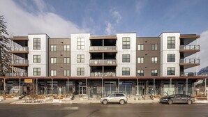 Un immeuble à plusieurs étages doté d’une architecture moderne, avec des balcons et de grandes fenêtres.
