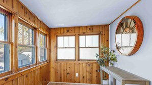 Ein Zimmer mit Holzvertäfelung, einem großen Spiegel, einer Holzbank und einer Topfpflanze.