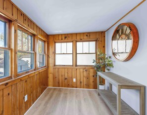 A room with wooden paneled walls, a large mirror, a wooden bench, and a potted plant. - Casa Blue - Spacious and updated Home In Wyoming (Wyoming)