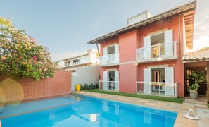 A two-story house with a swimming pool, a balcony, and a garden with flowering plants. - House w/ Pool 200 m From the Beach Pro0003 (Camaçari)