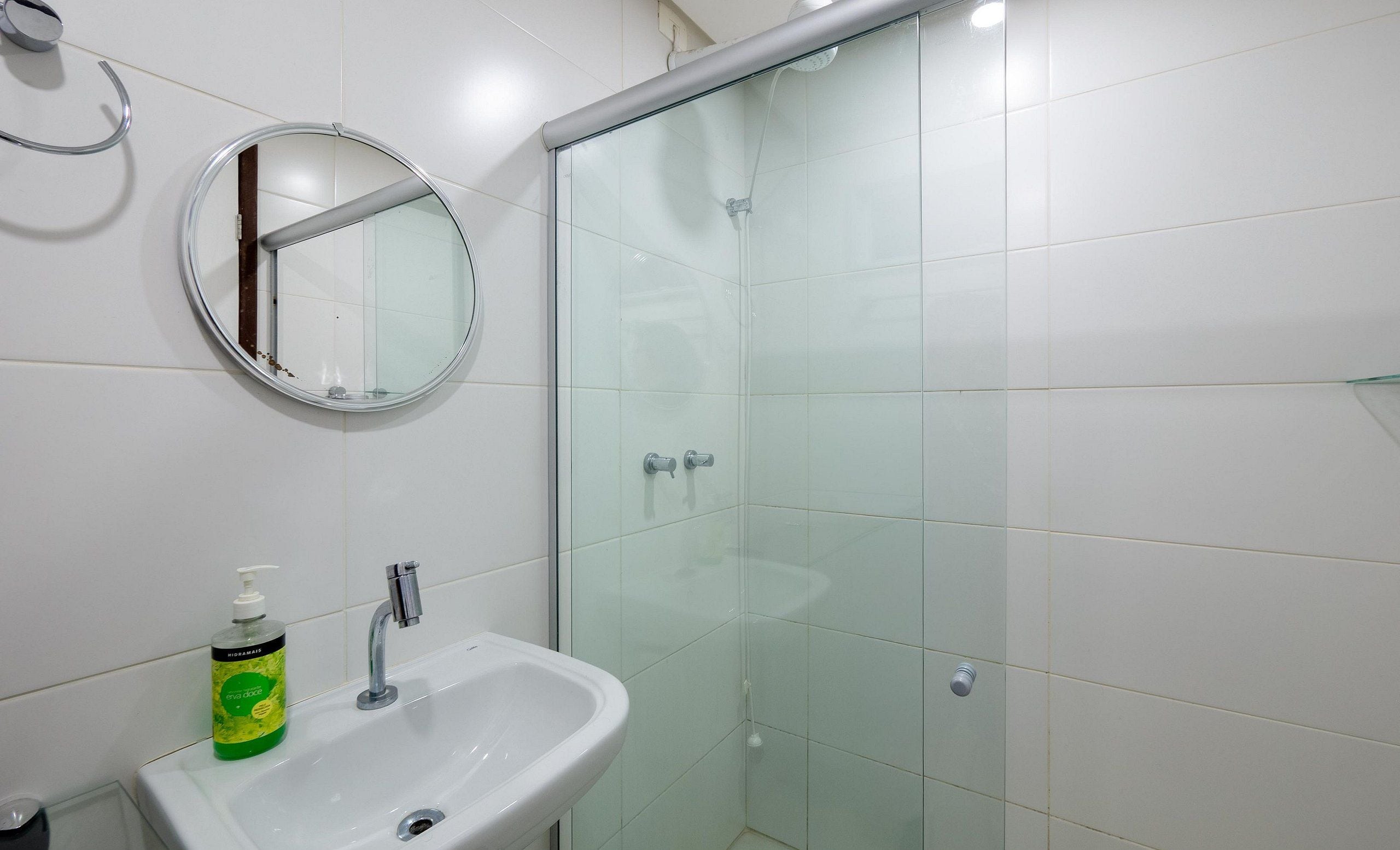 Un bagno con lavandino, specchio e cabina doccia in vetro.