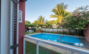 A swimming pool with a white deck, surrounded by lush greenery and palm trees. - House w/ Pool 200 m From the Beach Pro0003 (Camaçari)