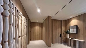 A modern interior with a wooden panel wall, a reception desk, and a framed picture on the wall. - Lujo Frente al Mar para 8 (Nay.)