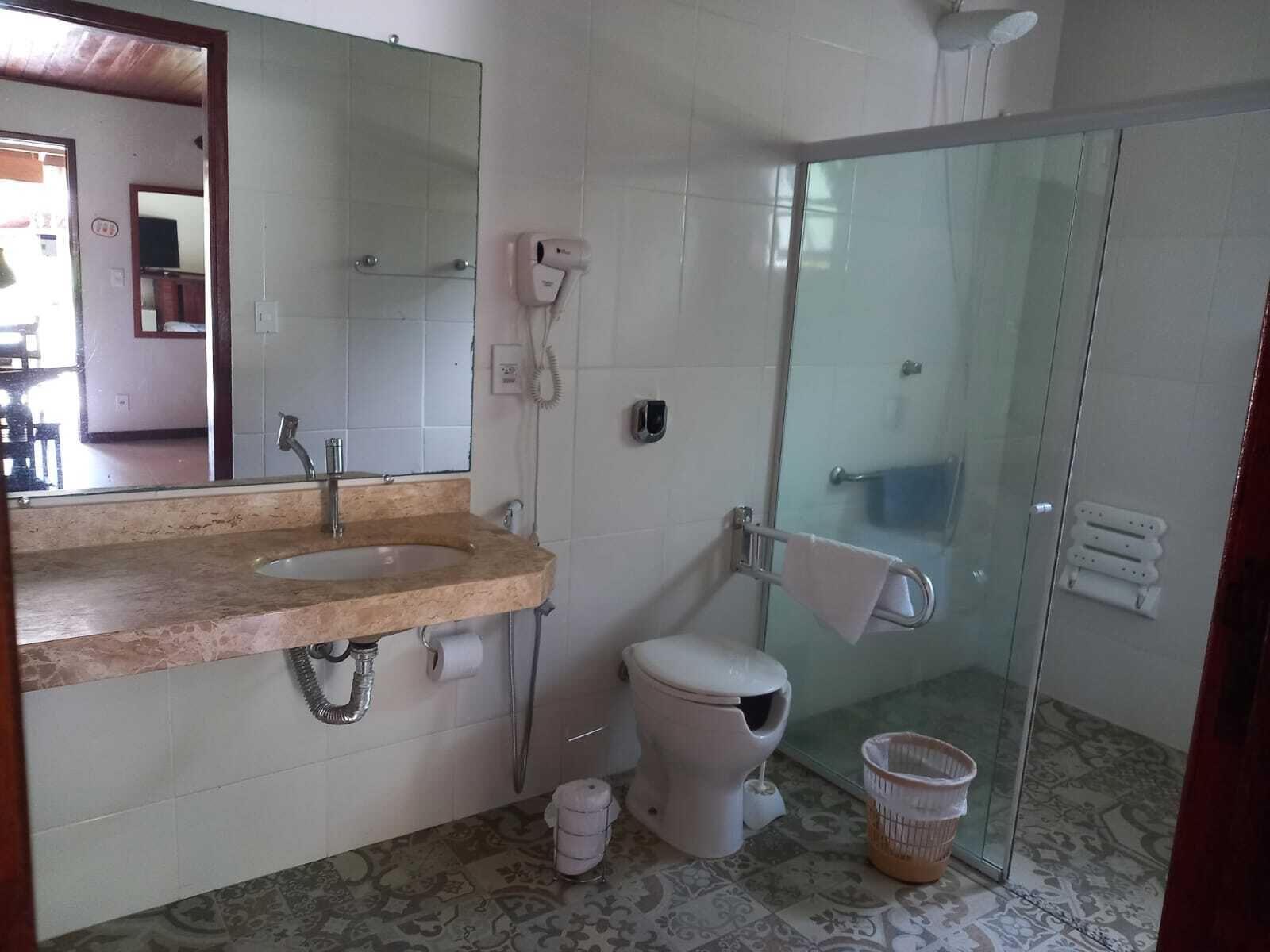 A bathroom with a sink, toilet, and glass shower enclosure.