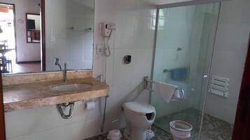 A bathroom with a sink, toilet, and glass shower enclosure.