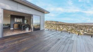 Un edificio moderno con zona de comedor y amplios ventanales con vistas a un paisaje urbano.