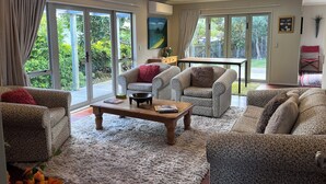 Un salon spacieux avec une grande fenêtre, une table basse et des canapés à motifs.