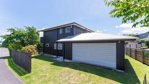 Un bâtiment à deux étages avec un garage et une cour clôturée.