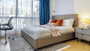 Un dormitorio moderno con una cama grande, un escritorio y una silla.
