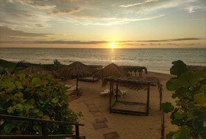 På stranden, solsenger, parasoller og massasje på stranden