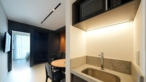 A modern kitchen with a granite countertop, stainless steel sink, and a microwave. - Porto 2 Life Muro Alto Resort - GAV Resorts (N. São do Ó)