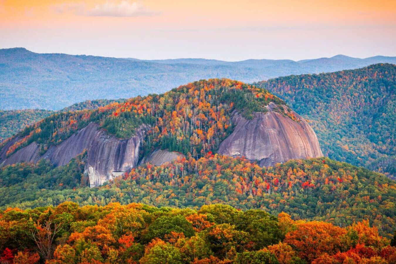 Un paysage montagneux caractérisé par une formation rocheuse imposante et une forêt dense.