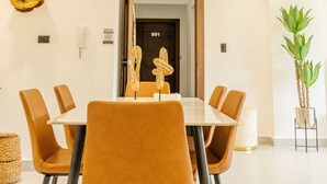 Un comedor moderno con una mesa rectangular, seis sillas y una decoración de pared.