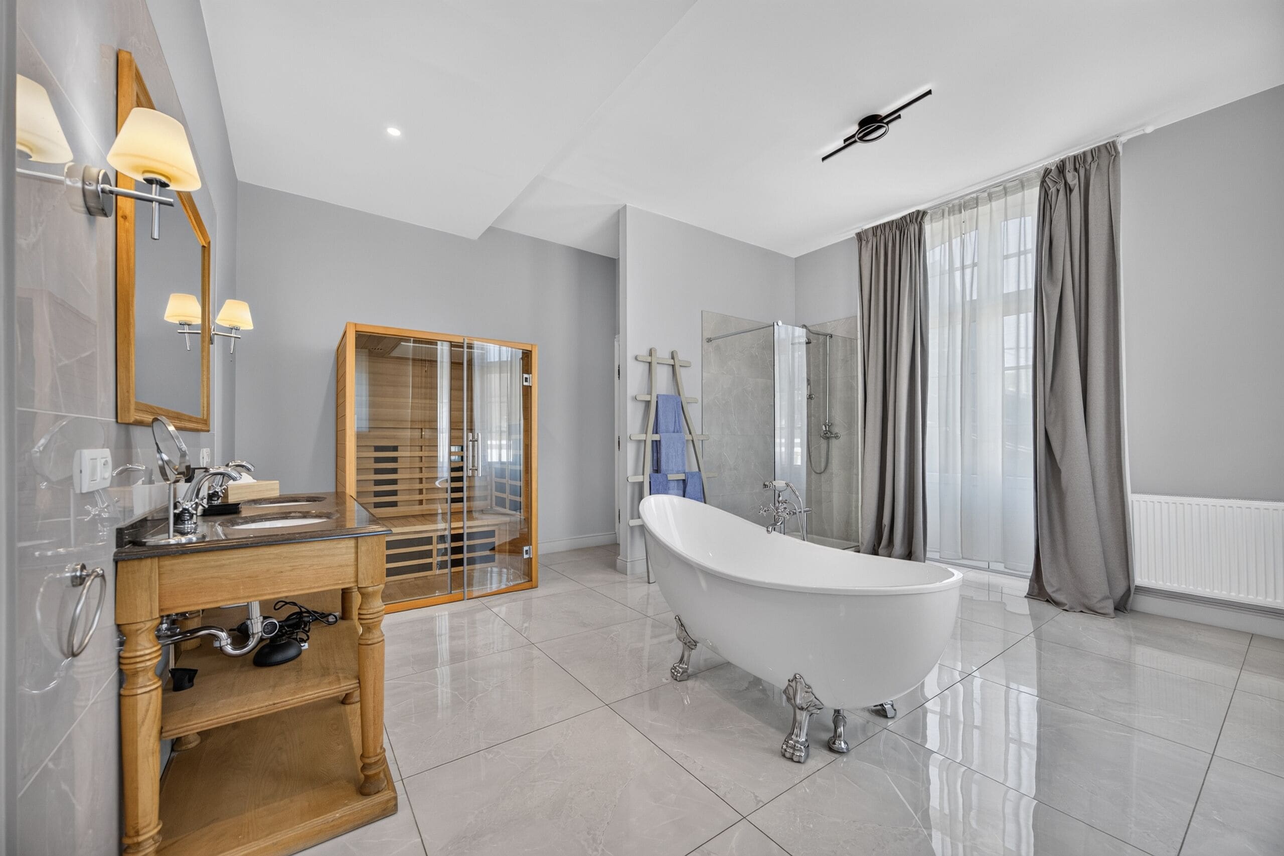 Ein modernes Badezimmer mit freistehender Badewanne, einem Holzkosmetikschrank mit Spiegel und einer separaten Duschkabine.