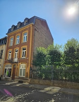 A corner building with a brick facade, multiple windows, and a visible entrance.