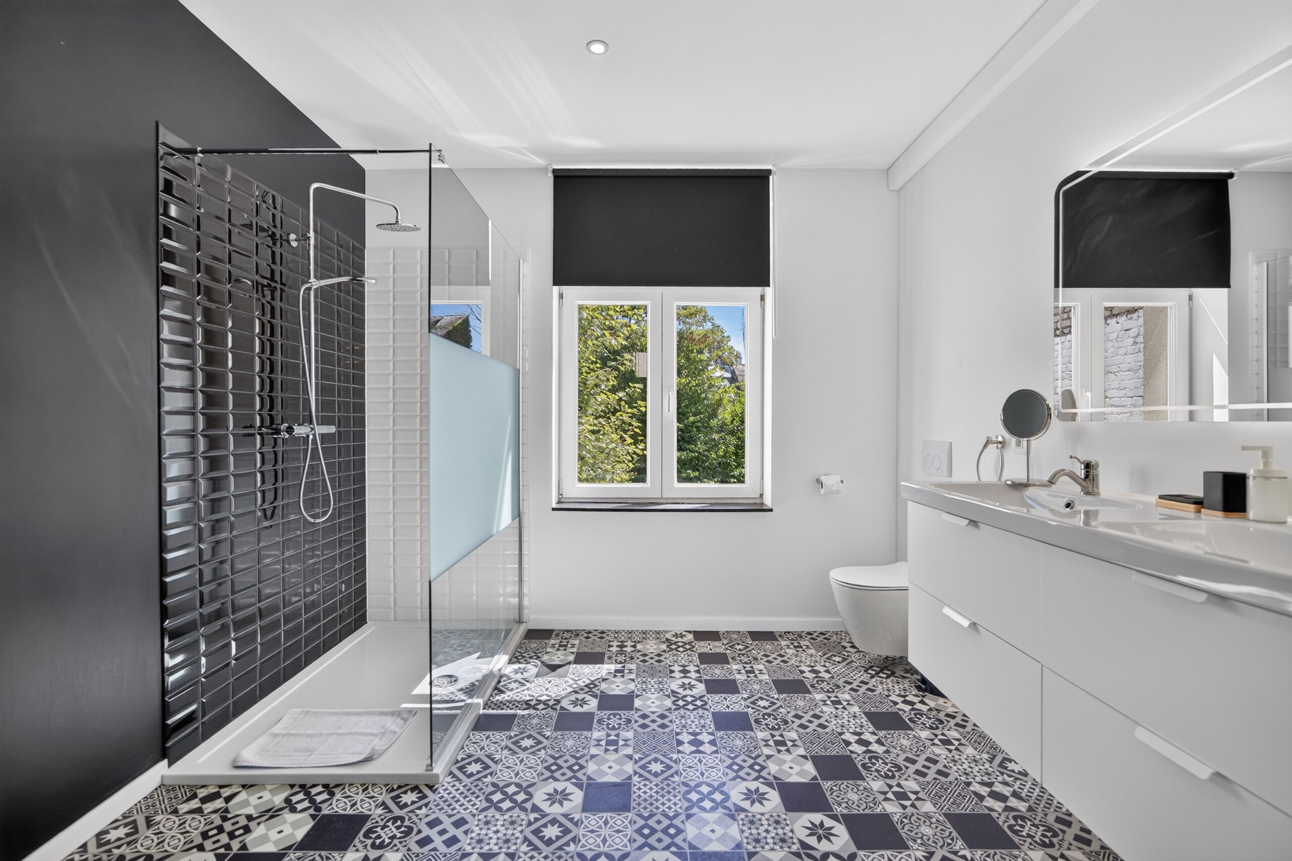 A modern bathroom with a shower, toilet, and sink.