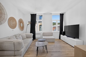 Una sala de estar moderna con un sofá, una mesa de centro y un televisor.