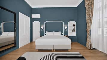 Un dormitorio moderno con una cama grande, un espejo, un armario y una mesita de noche con una lámpara.