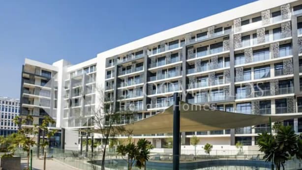 A modern hotel with multiple floors, a covered outdoor area, and a central courtyard with a pool. - 106 Bloomfields Executive STU Gate Masdr (Madinat Zayed)