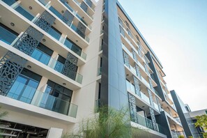 A multi-story hotel with balconies, large windows, and a modern architectural design. - 106 Bloomfields Executive STU Gate Masdr (Madinat Zayed)