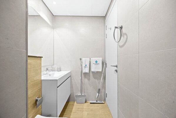 Une salle de bain moderne équipée d’une douche, de toilettes et d’un lavabo.
