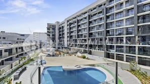 A modern multi-story hotel with a rooftop pool and outdoor seating areas. - 106 Bloomfields Executive STU Gate Masdr (Madinat Zayed)