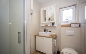 A bathroom with a shower, a sink, a toilet, and a window. - Beautiful home in Mali Ston with WiFi (Mali Ston)