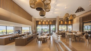 En rymlig hotellobby med ett område för buffé, sittplatser och stora fönster som erbjuder utsikt över omgivningarna.