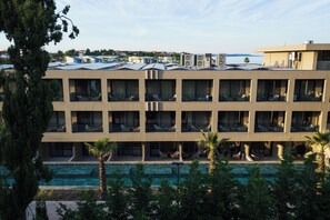Un hôtel à plusieurs étages, doté de balcons et d’une piscine.