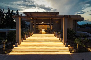 Un escalier menant à l’entrée d’un bâtiment, avec une passerelle couverte au-dessus.