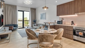 Un appartement moderne comprenant un coin repas, une cuisine et un salon.