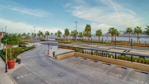 Un espace de stationnement avec des places délimitées et un chemin piétonnier longeant la rive.