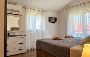 A bedroom with a bed, a TV, a dresser, and a window with curtains. - Beautiful apartment in Vir with WiFi (Vir)