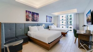 A modern hotel room with two beds, a desk, and a seating area. - Stylish 2 Queen Studio • Pool & Gym (Hollywood)