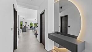 Ein modernes Interieur mit einem eleganten Flur, einer eingebauten Bank und einem großen Spiegel.