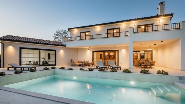 Ein modernes, zweistöckiges Haus mit Swimmingpool, Sitzgelegenheiten im Freien und Essbereich.
