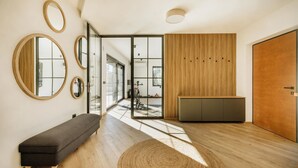 Ein modernes Interieur mit einer Bank, Spiegeln, einer Wand aus Holzpaneelen und einer Tür.