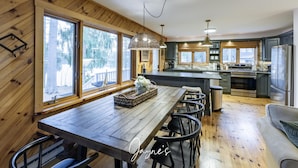 A wooden interior with a dining area, kitchen, and large windows. - Dock n Dive (Bala)