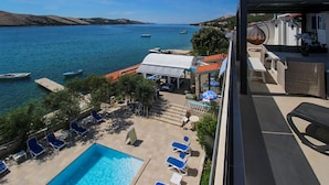 A rooftop pool area with lounge chairs and a view of the sea. - Amazing apartment in Stara Novalja with heated swimming pool (Stara Novalja)