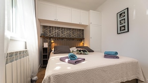A bedroom with a bed, a radiator, a wardrobe, and a wall-mounted picture frame. - Nice apartment in Silo with WiFi (Silo)
