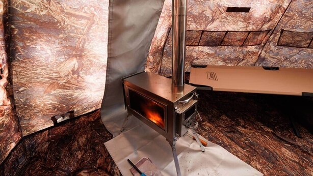 A wood-burning stove in a room with a rustic, wooden interior.
