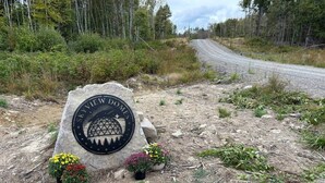 A stone monument with a circular emblem and two flower pots.
