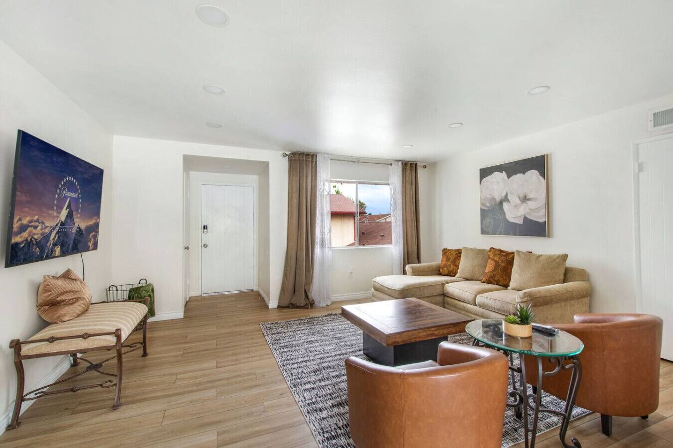 A living room with a sofa, armchairs, a coffee table, and a TV.