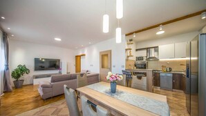 Eine moderne Wohnung mit Wohnzimmer, Essbereich und Küche.