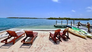 A beach with lounge chairs and kayaks. - El Arca (Isla Tintipán)