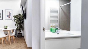 A modern bathroom with a white sink, green soap dispenser, and a towel rack. - Spacious, modern, and central 2-bedroom apartment with 1 bathroom in Madrid (Madrid)
