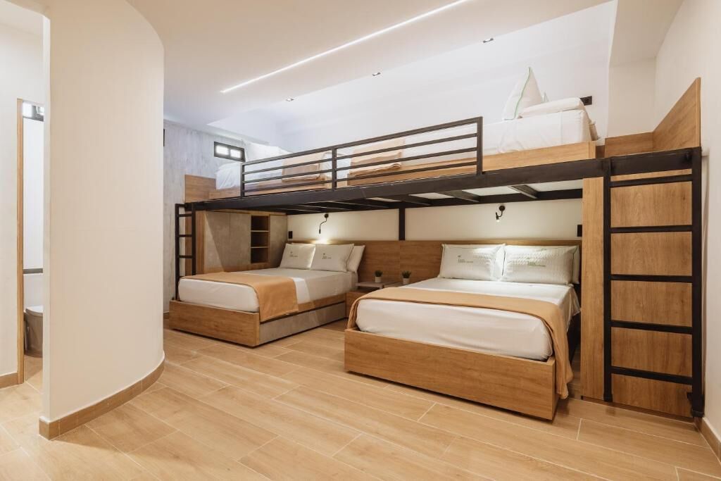 A dormitory-style room with bunk beds, wooden headboards, and a curved wall.